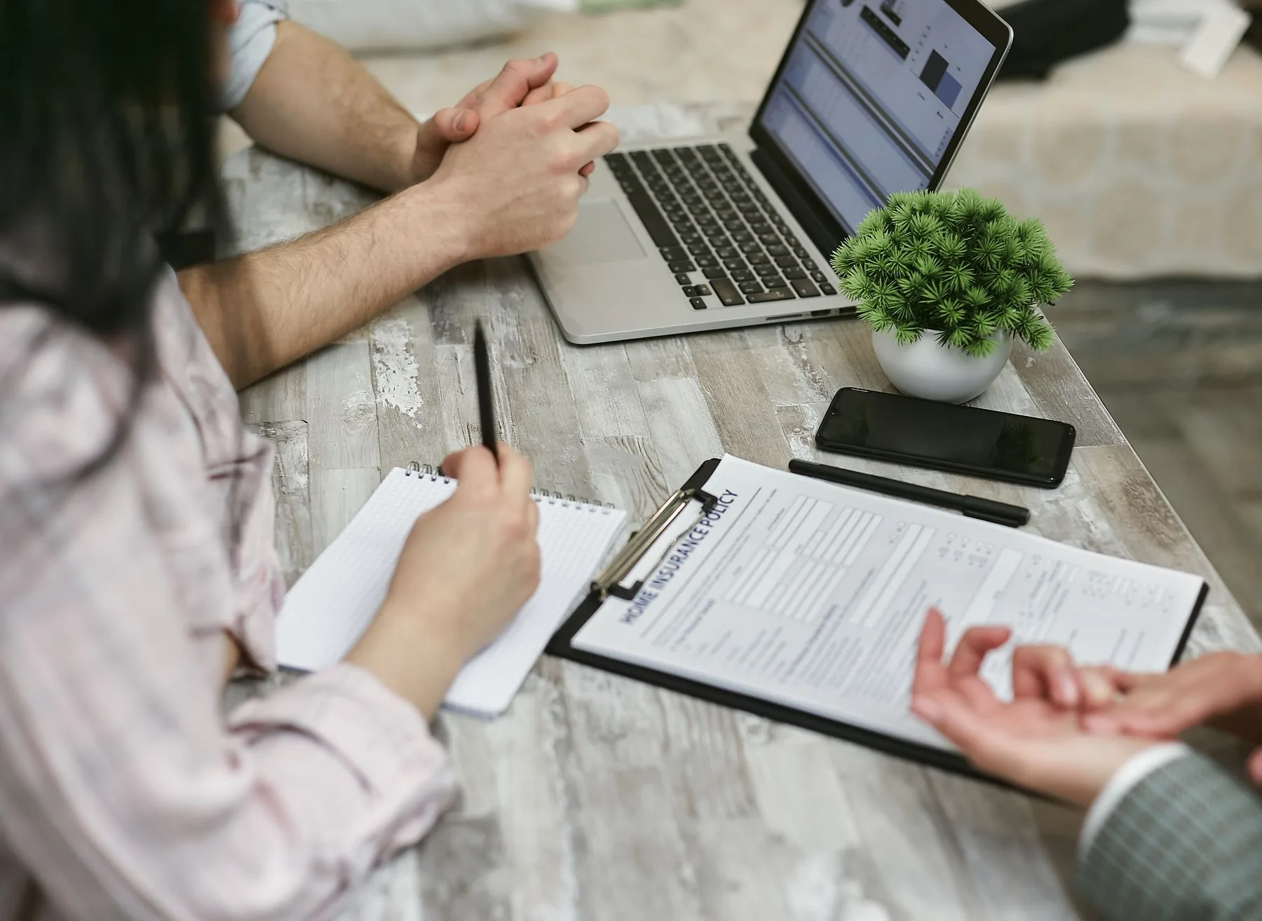 Clients and an advisor reviewing a home insurance policy together.